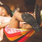 Female model wearing The Trenza  leather flip flop sustainably made with upcycled tire soles by  Brave Soles.